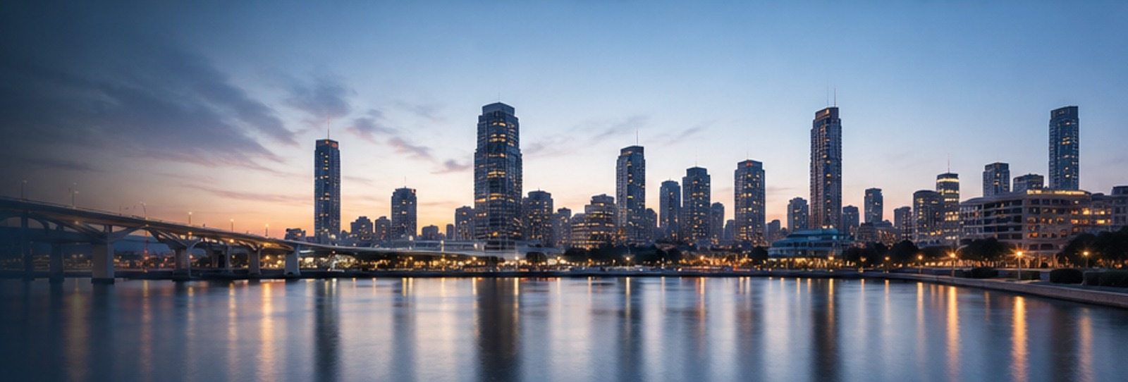 Waterfront city skyline at dusk reflected in calm water